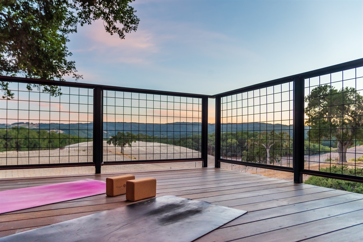 A peaceful wooden deck for yoga and meditation with stunning hillside views.
