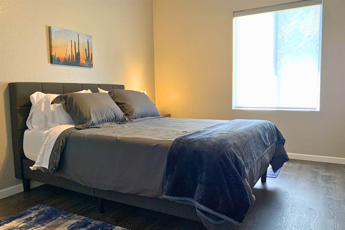 Bedroom #2:Comfortable queen bedroom with soft linens, warm lighting, and modern desert-inspired art. 