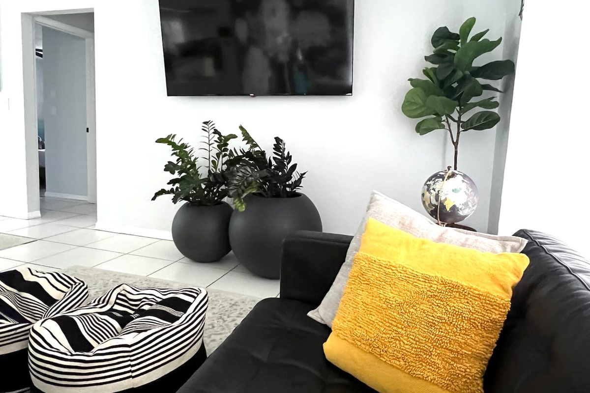 Step into this modern living room, featuring sleek, minimalist design with clean lines and neutral tones. A 70-inch smart TV takes center stage, perfect for movie nights or catching up on your favorite shows