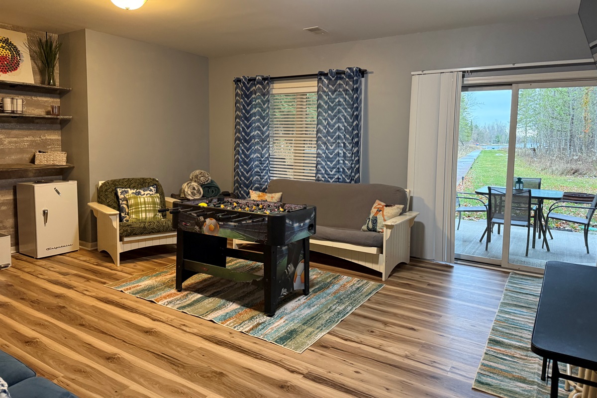 Walkout level living room equipped with smart television, games and foosball table. Walkout the sliders to patio,hot tub, and THE LAKE!