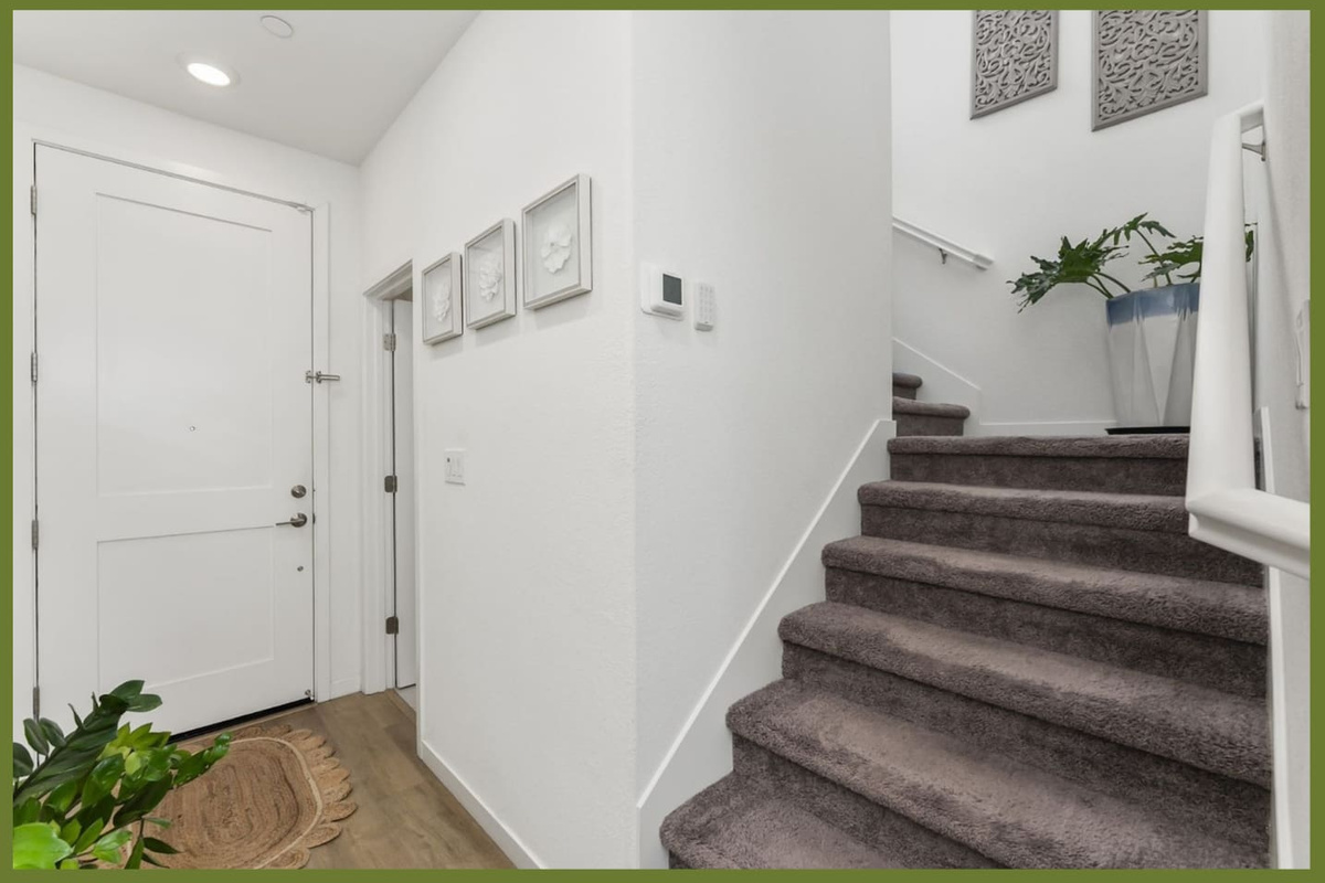Entryway with staircase access, front door entry, and a clean arrival path into the home.