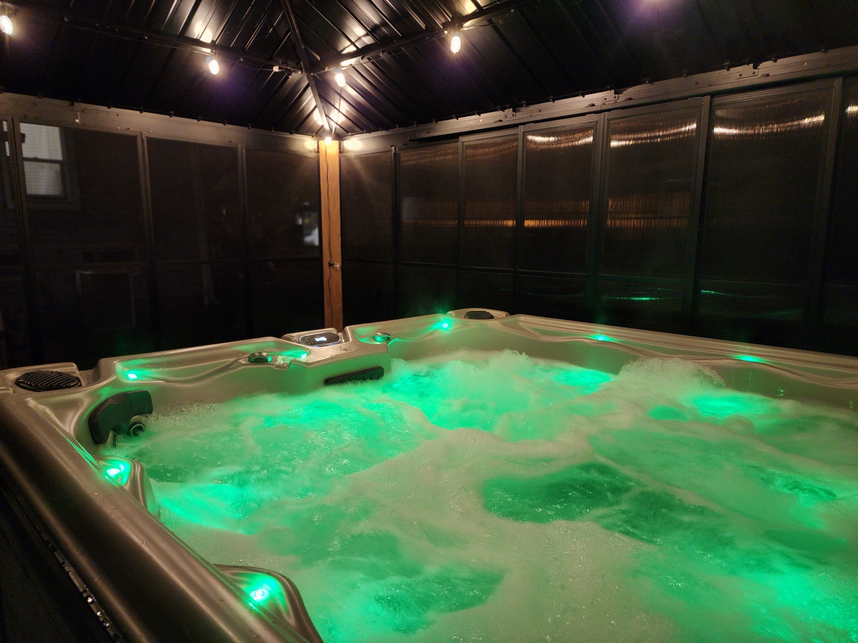 6-person hot tub, fully covered, screened, tinted for privacy, with soft string lights