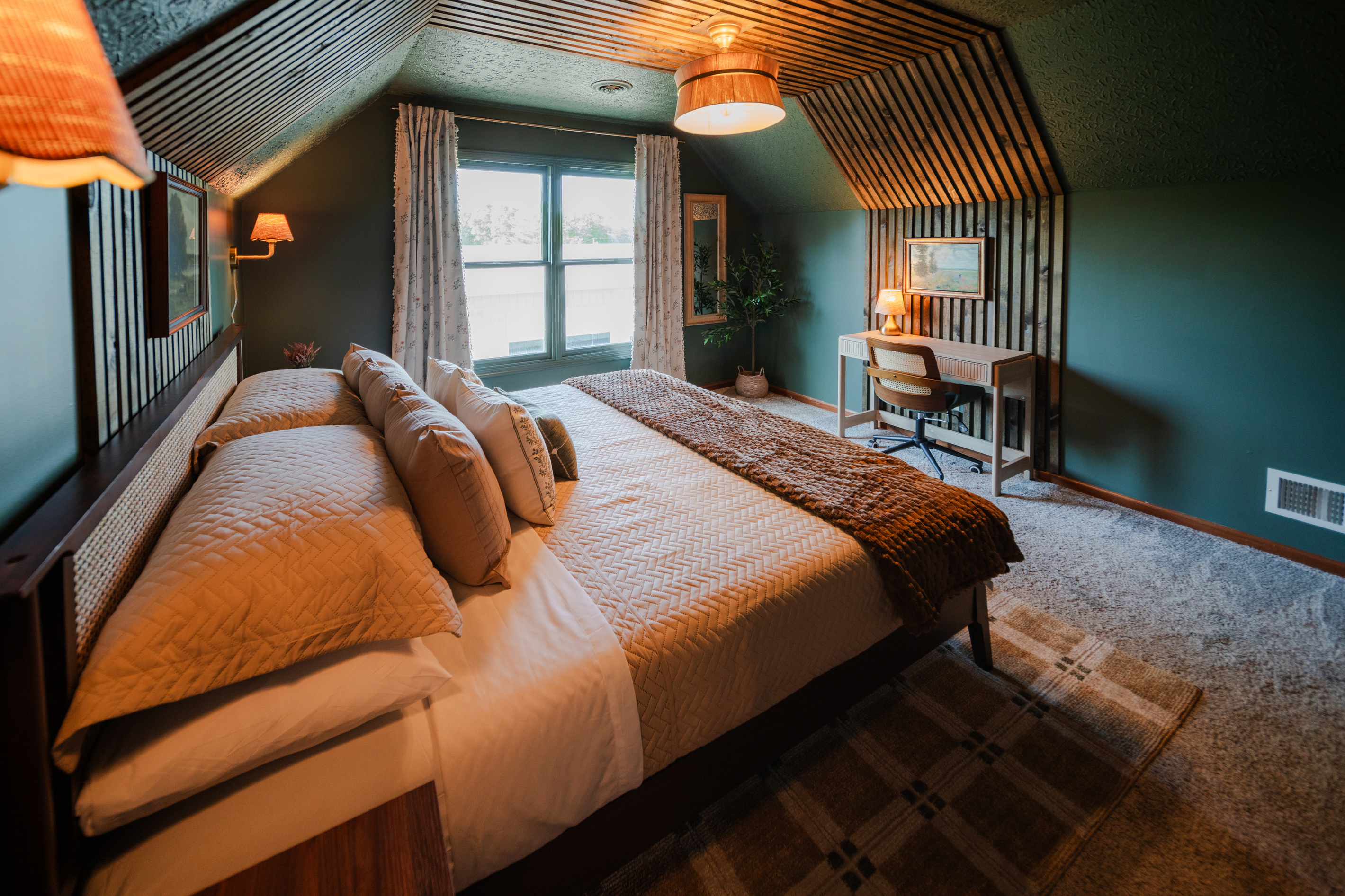 Upstairs king bedroom with a workspace and peaceful woodland views.