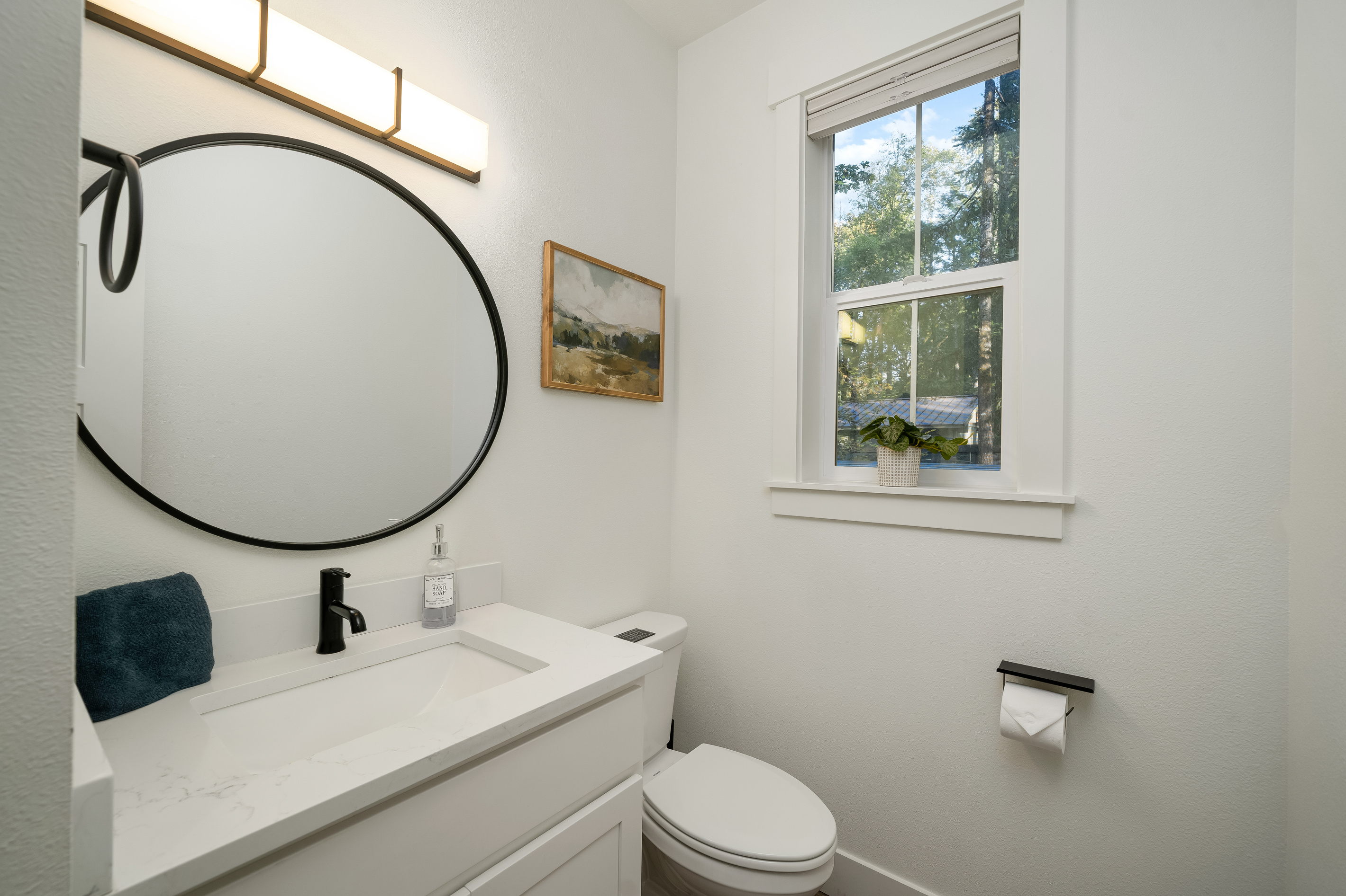 A bright half-bath with forest views — no waiting in line here.