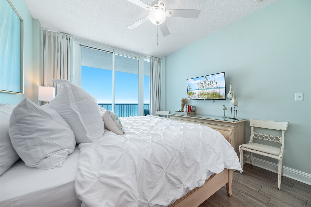 Enjoy the perfect blend of comfort and coastal beauty in this inviting bedroom with direct balcony access and stunning ocean views.