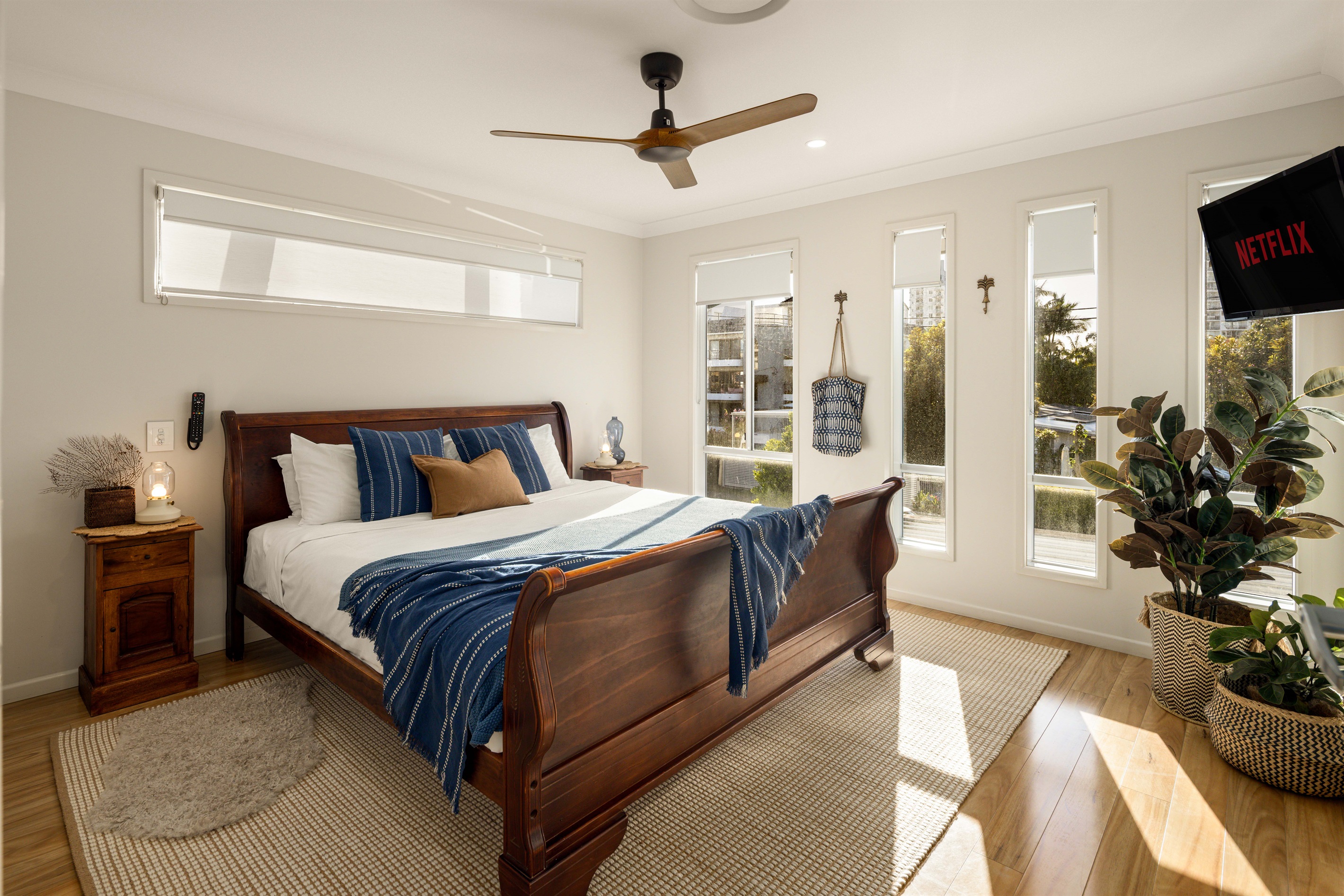 Beautifully appointed Suite 4 featuring a classic wooden sleigh bed and abundant natural light.