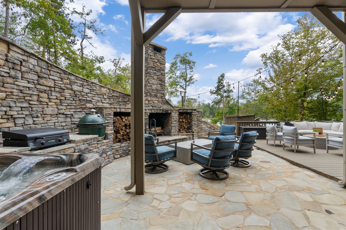 Relax outdoors with dining space, a soothing hot tub, and comfortable seating around the fireplace—perfect for evening meals, quiet soaks, and cozy nights under the stars.