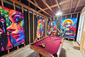 Garage game room with pool table, foosball, and air hockey under blacklight murals