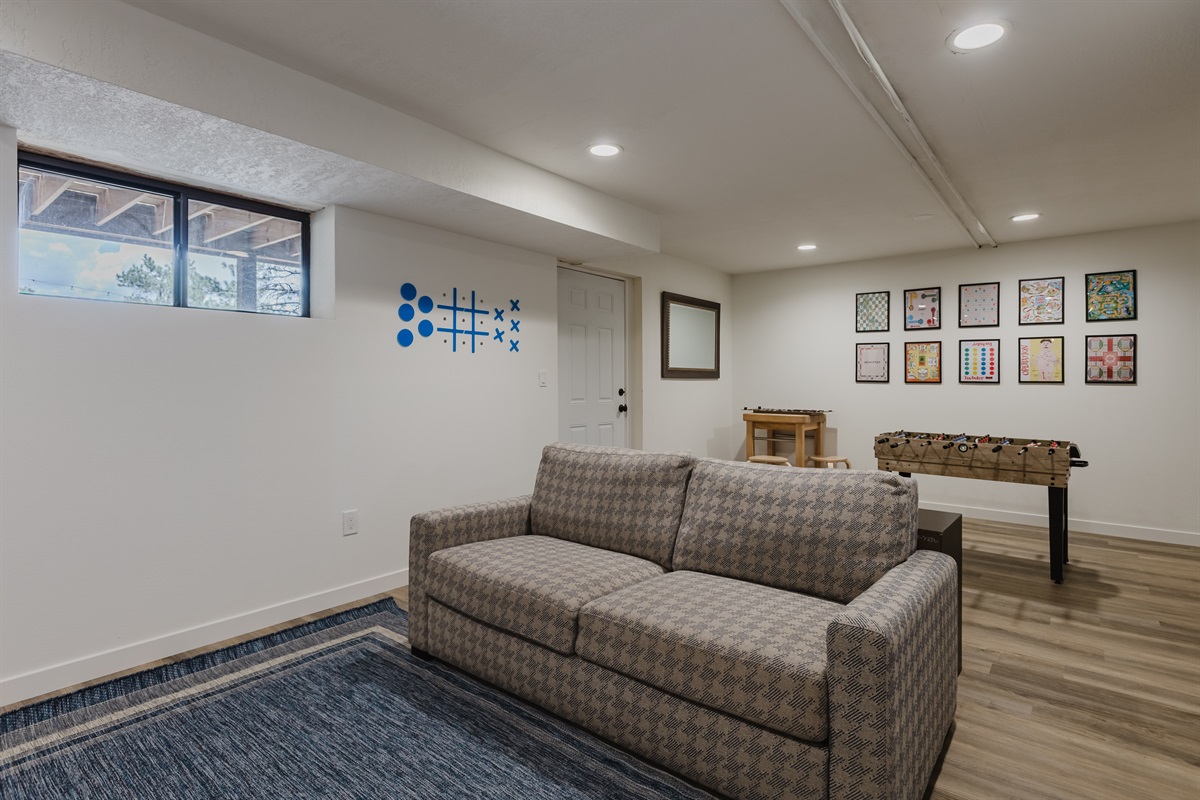 Game room includes a pull-out couch, providing flexible sleeping arrangements and entertainment all in one space.
