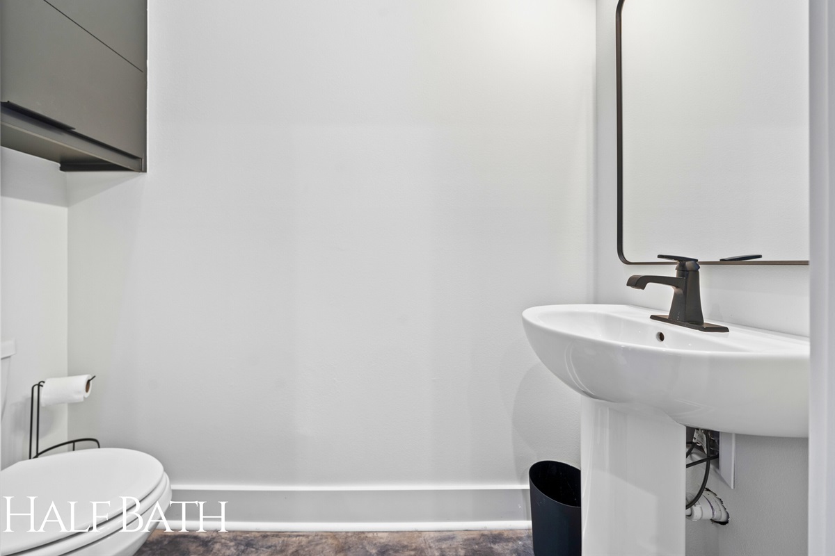 A minimalist half bath with sleek, modern finishes and a clean design, providing a convenient and stylish addition to the home.