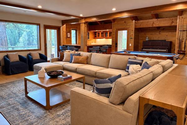Large living room sectional adjacent to pool table, wet bar, dining table