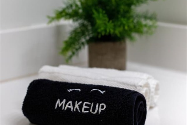 Experience our serene bathroom with plush towels and a touch of greenery.