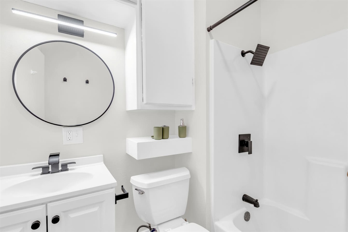 Bathroom with shower/tub combo and hotel-style touches.
