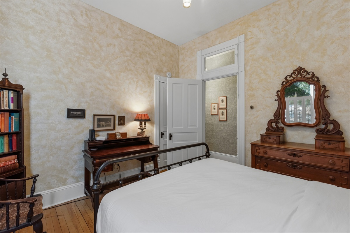 Antique desk setup in bedroom w/ mirror & classic chair