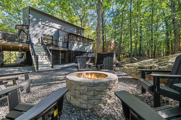 Rustic stone-lined fire pit  and Adirondack chairs, perfect for nighttime gatherings and roasting s'mores