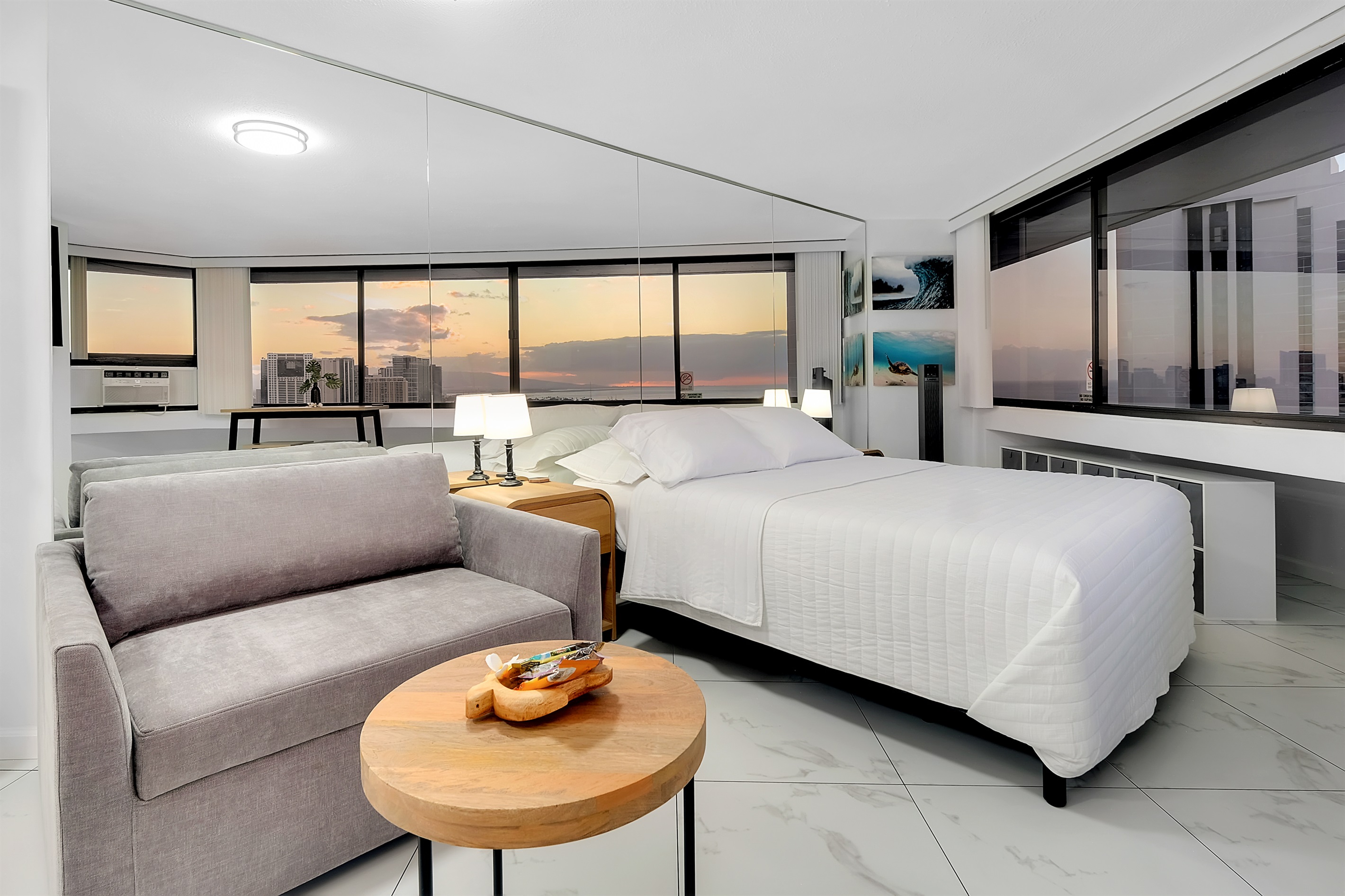 Relax in modern island comfort as the sun sets over the Pacific. This elegant Waikīkī studio features panoramic ocean and city views, plush bedding, and serene décor — creating the perfect retreat to end your day in paradise.