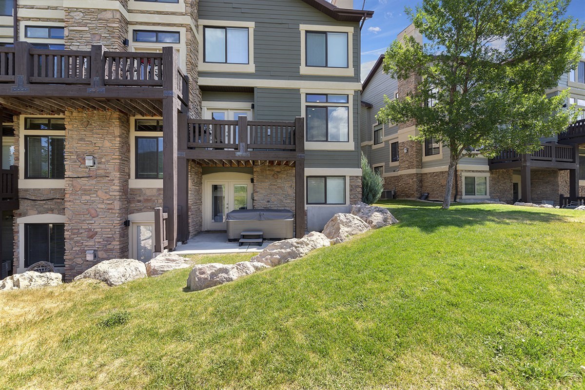 Sophisticated townhome exteriors blend rustic stone accents with modern finishes, complemented by private outdoor spaces and manicured green lawns—designed for both comfort and elevated living.