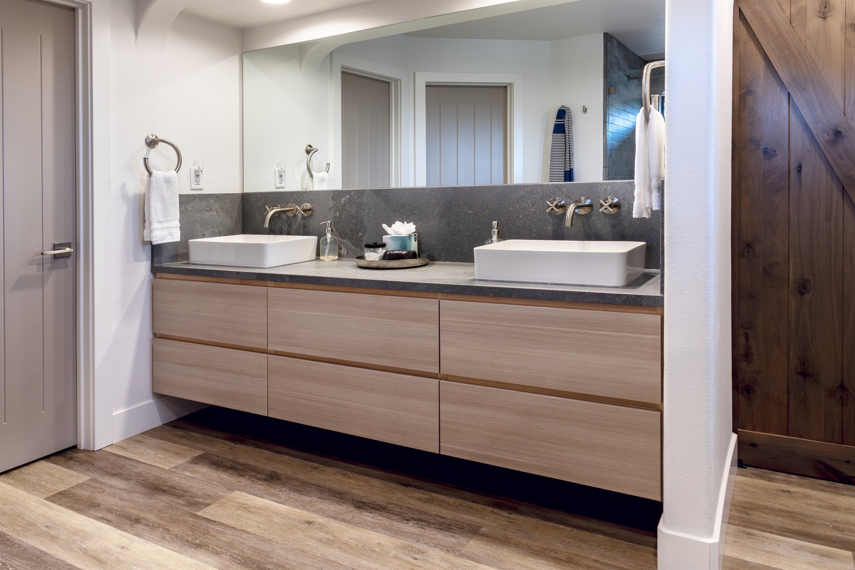 His and hers vessel sinks, a dramatic stone countertop, and a hand-crafted barn door entry — the master bath is as functional as it is beautiful.