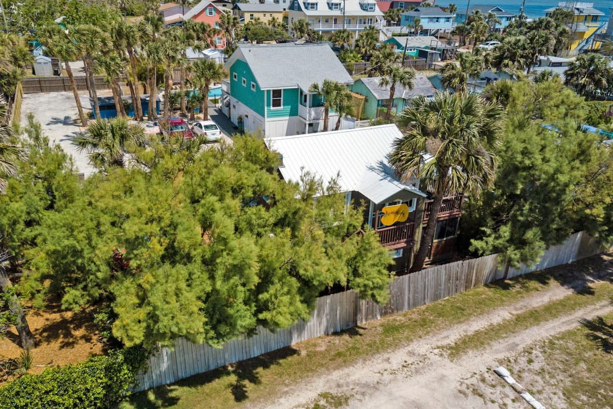 The bungalow tucked into its green corner, with the beach path running along past the fence. It is exactly the sort of spot people mean when they say they want to be near the water without being right on top of it.