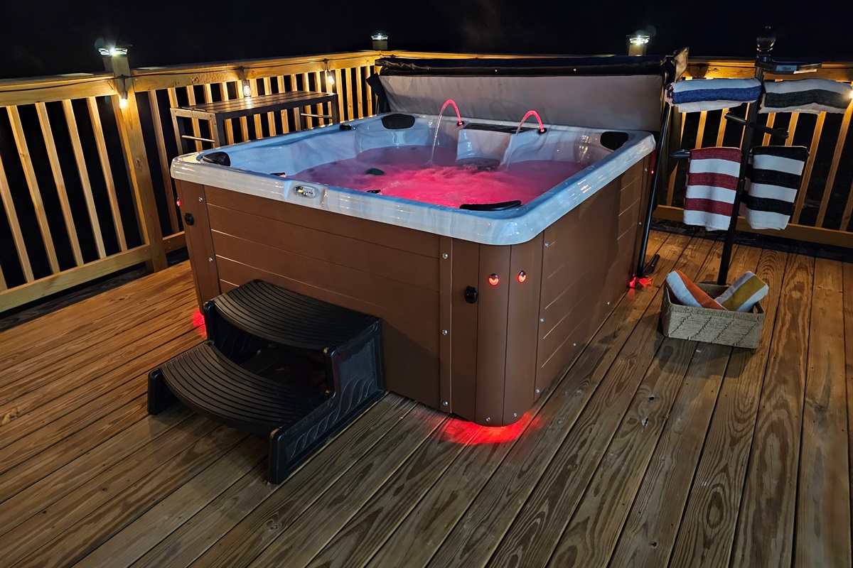 Soak in your private hot tub under glowing deck lights—perfect for romantic nights beneath the stars