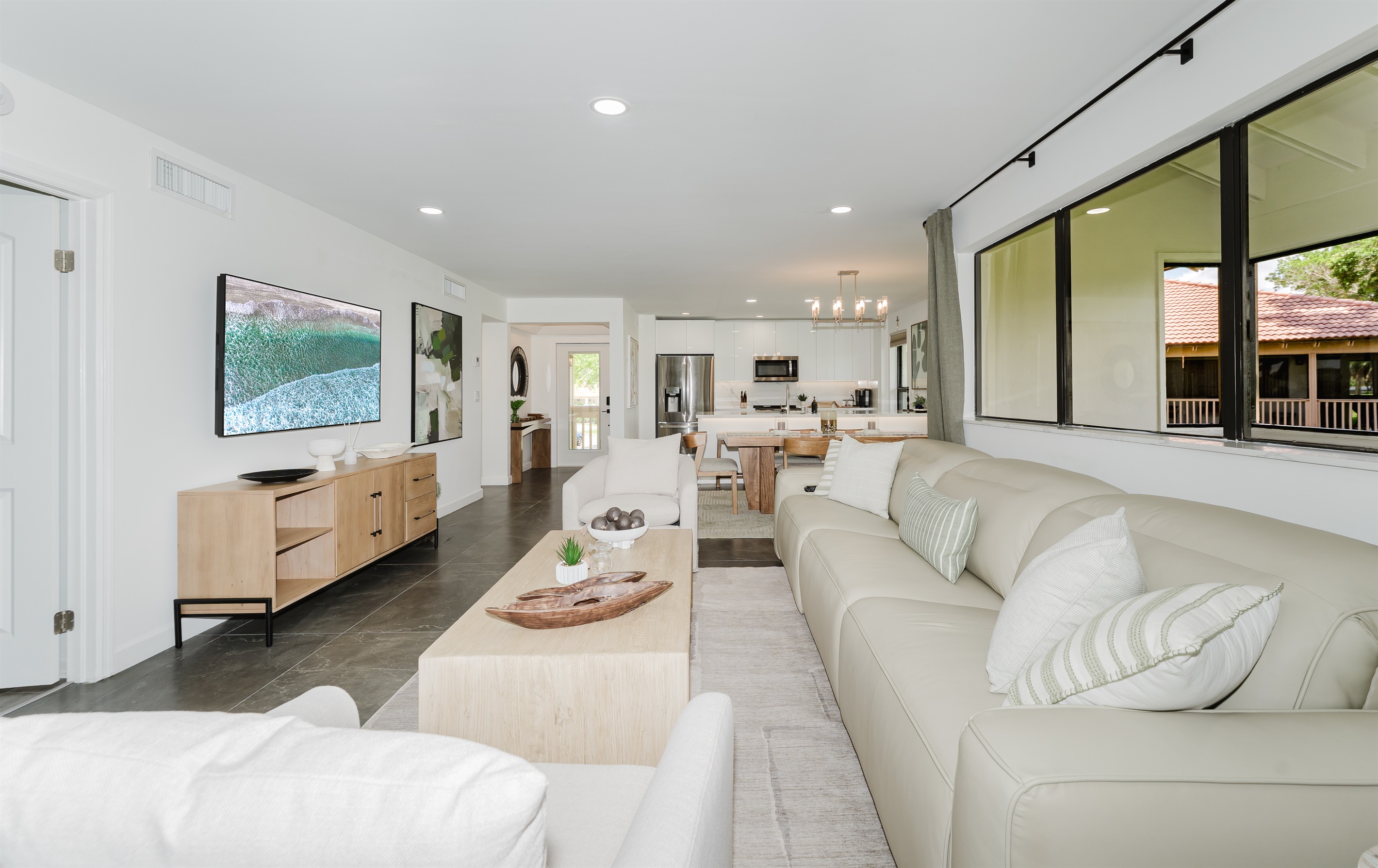 Seamless indoor-outdoor feel with large windows overlooking the fairway. Bright, open living space filled with natural light and golf course views. Comfortable seating is perfect for relaxing after a day at the beach or golf. 