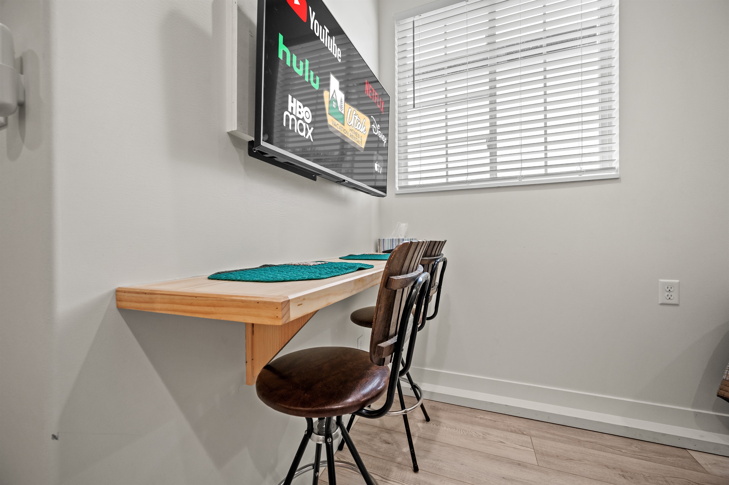 Bright studio dining nook with breakfast bar and Smart TV — ideal for enjoying meals