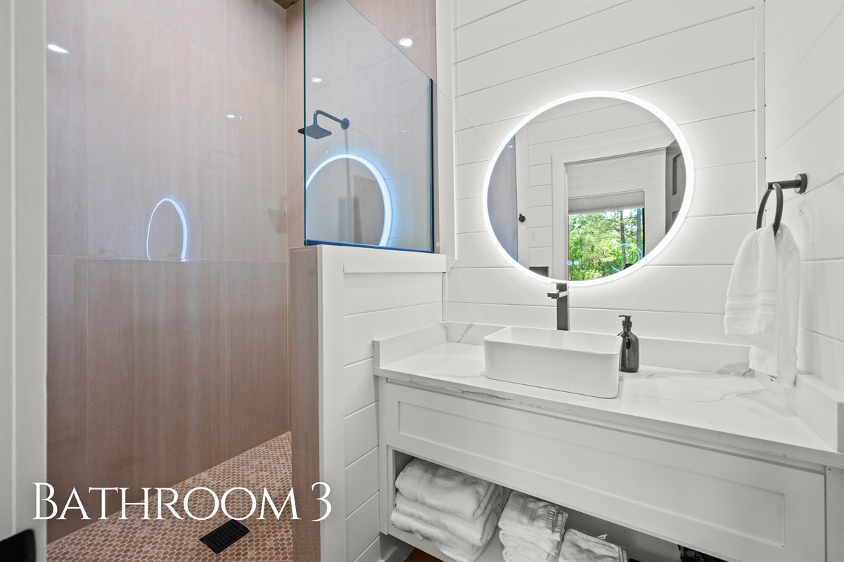 Clean modern finishes, warm lighting, and plenty of space continue throughout this beautifully styled bathroom, creating a comfortable and refreshing experience.