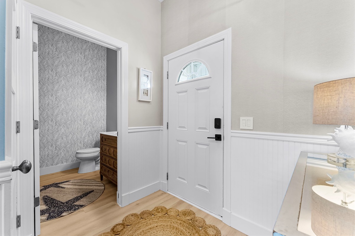 Convenient half bath paired with a full-size washer & dryer and custom ceiling-to-floor cabinets complete with all your laundry essentials.