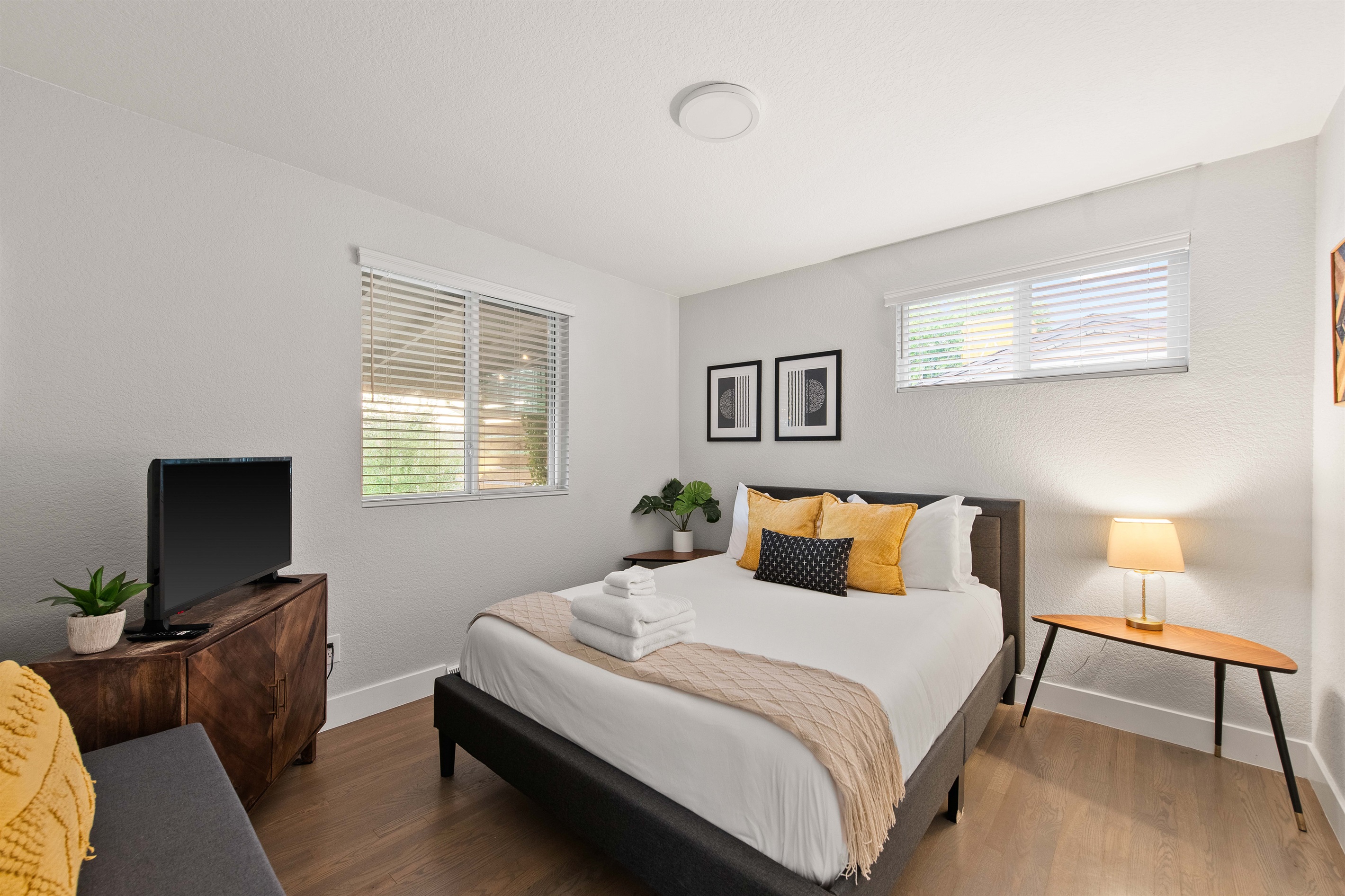 Bright queen bedroom with smart TV and workspace