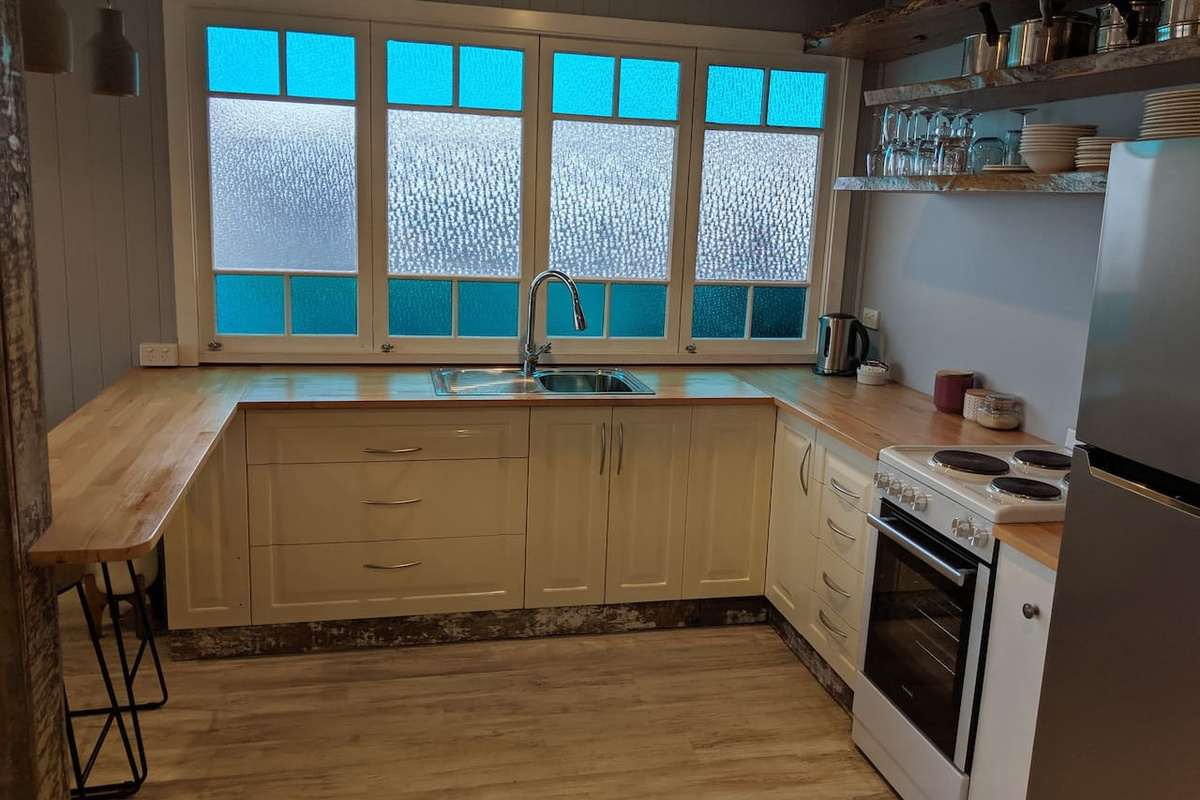 This well-equipped downstairs kitchen adds another practical living zone at Aaron's Beachside Boat House, complementing its Marcoola beachside setting.