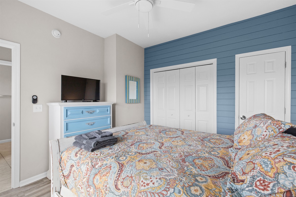 Cozy queen bedroom with TV and ample storage