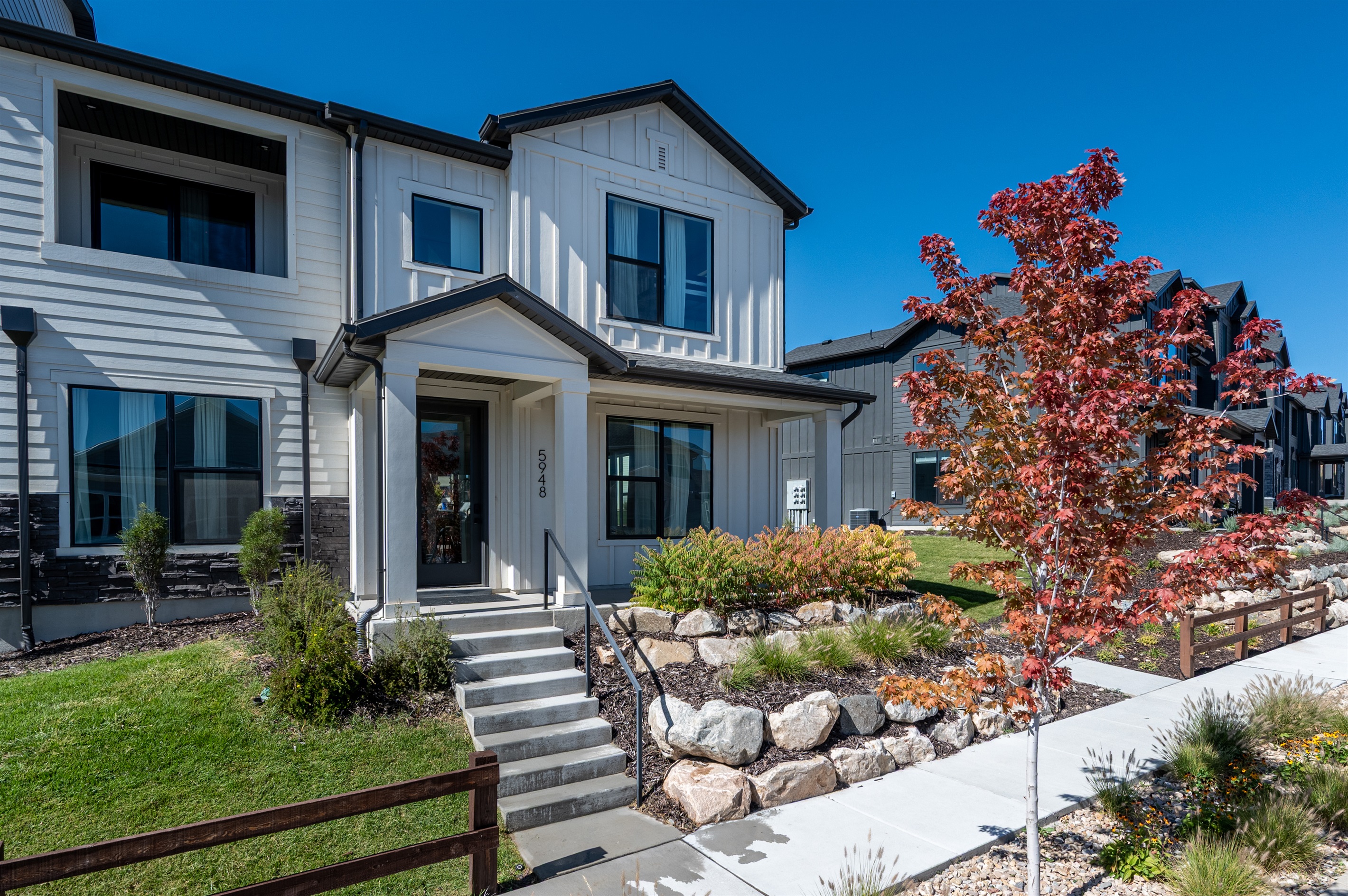 Front entrance of the home with landscaped yard and vibrant autumn colors.
