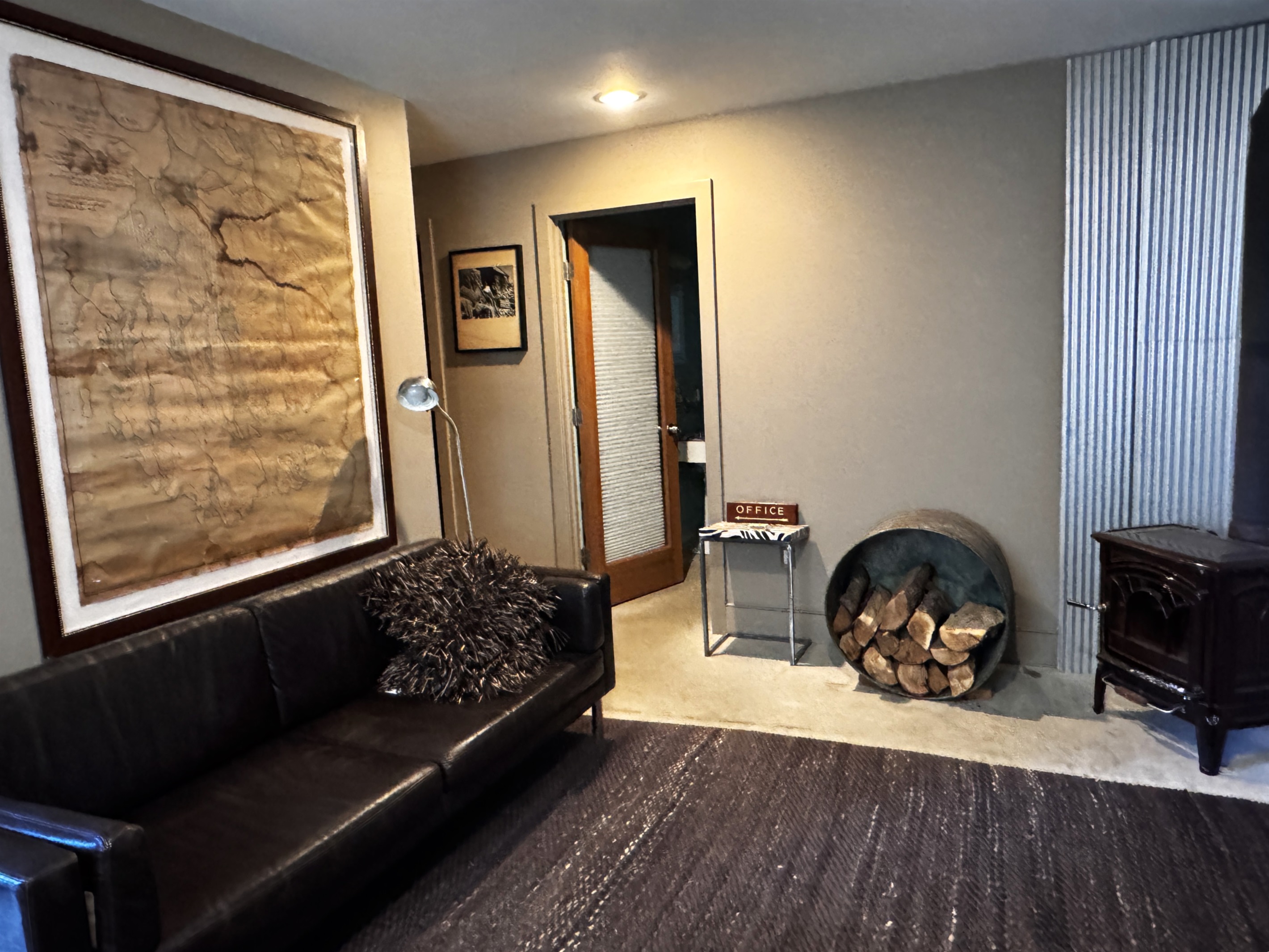 Lower level living area looking toward the dedicated guest bathroom and hallway leading to the twin guest room. This layout creates a private, self-contained suite for kids or secondary groups, away from the main level social hubs.
