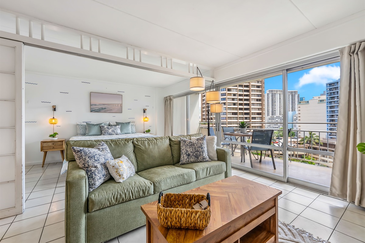 Angle view open floor plan showing living area and bedroom in background.  Sliding door can be utilized to separate areas and create privacy