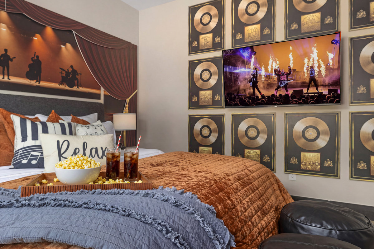 The concert plays on-screen beside a wall of records.