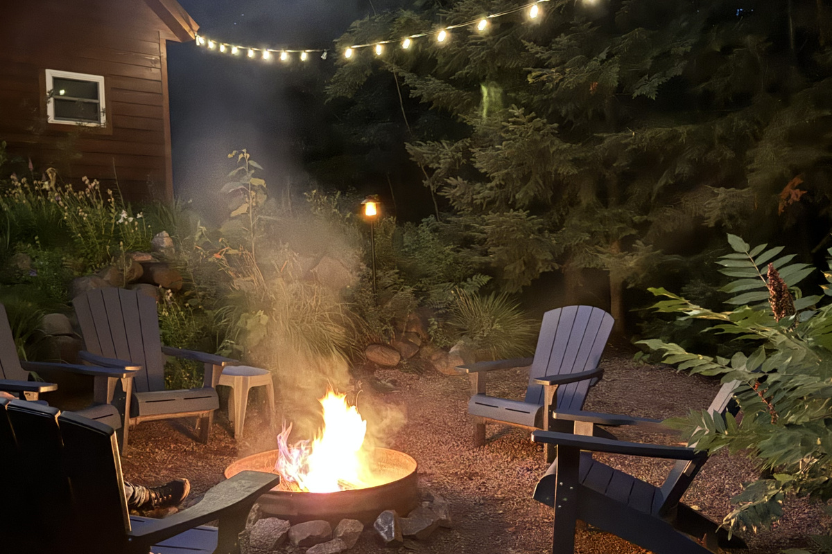 Evening Rock Garden Cottage campfire, provided wood. Solar string lights at dusk above firepit and rock garden for a relaxing ambiance. 