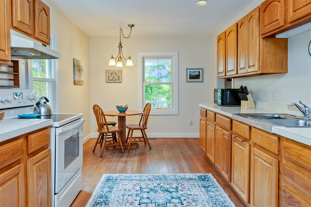 Bright and welcoming kitchen with warm wood cabinetry, modern appliances, and a cozy dining nook—perfect for morning coffee or casual meals.