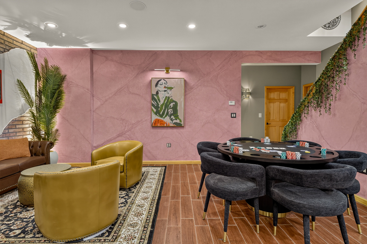Poker table with upholstered chairs and nearby lounge seating
