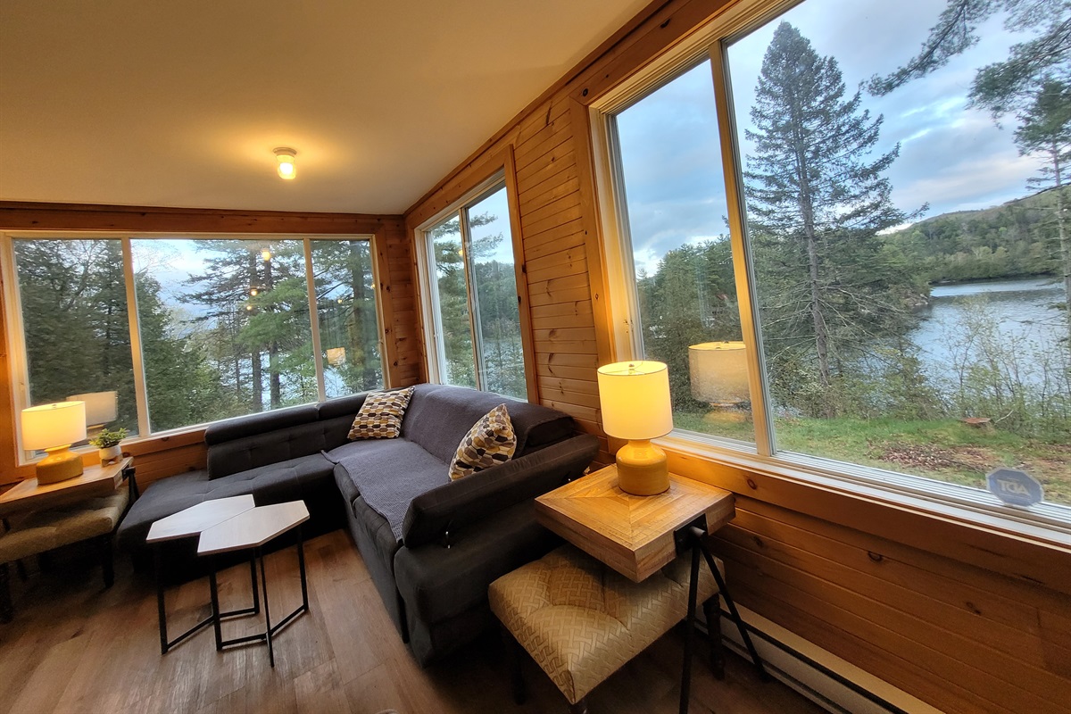 Corner of enclosed porch with dramatic lake view; lots of room to relax
