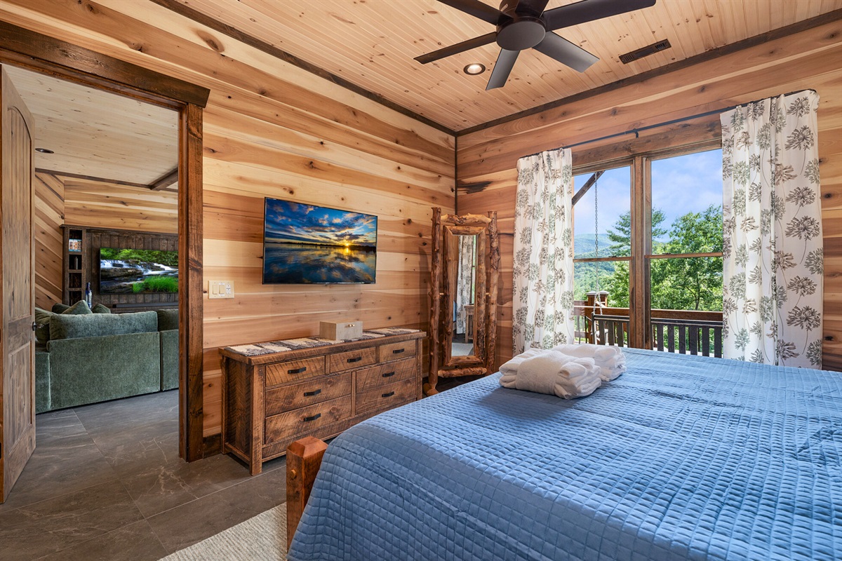 The comfortable downstairs master suite with a king bed, ready to provide a restful night's sleep.