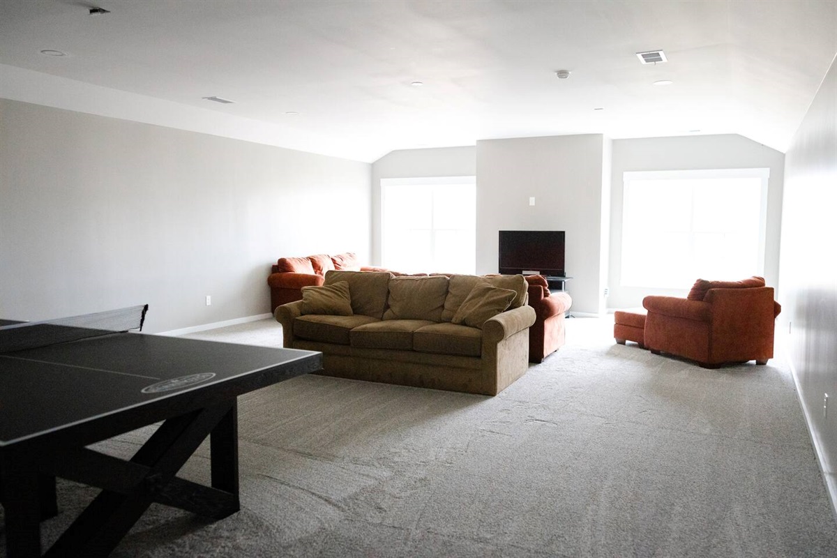 Photos don't capture just how large this additional 1200 sq. ft. of bonus area really is. Ping pong, toys for kids, board games, movie room (coming soon), work space on opposite side, and another twin bed. PLENTY of space to hang out here--very cozy.