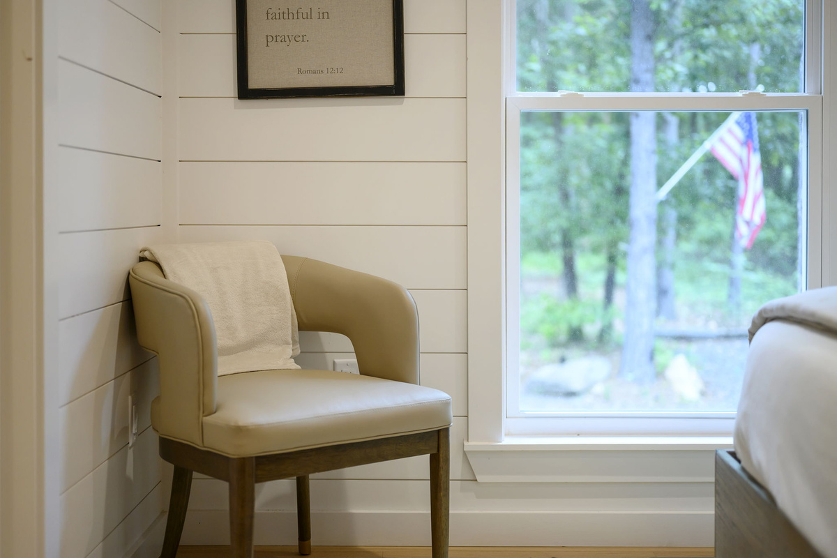A beautifully appointed queen bedroom featuring luxury design, high-end linens, and peaceful forest views.