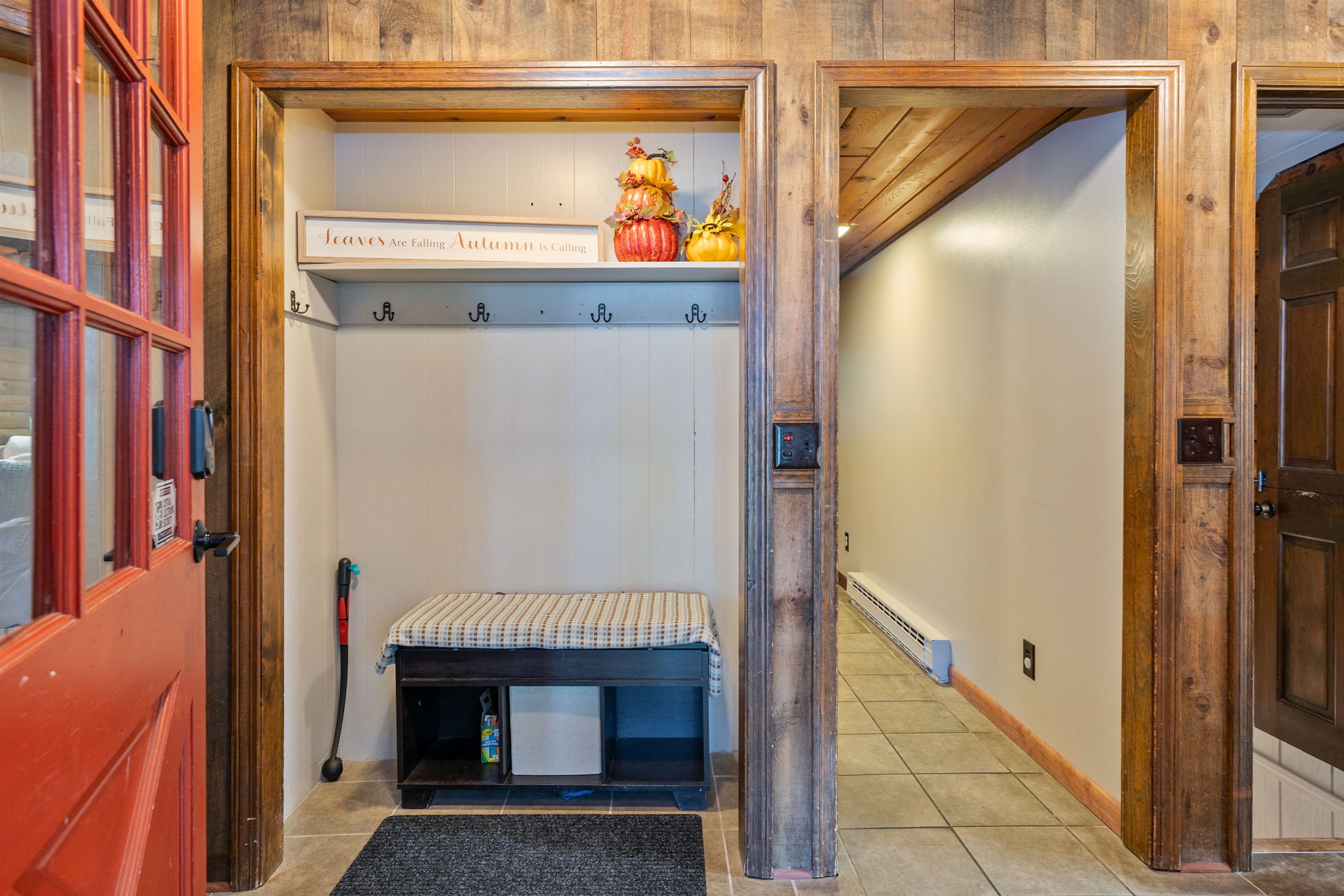 A warm and inviting mudroom with rustic wood accents, cozy bench seating, and seasonal décor that sets the tone for a comfortable stay.