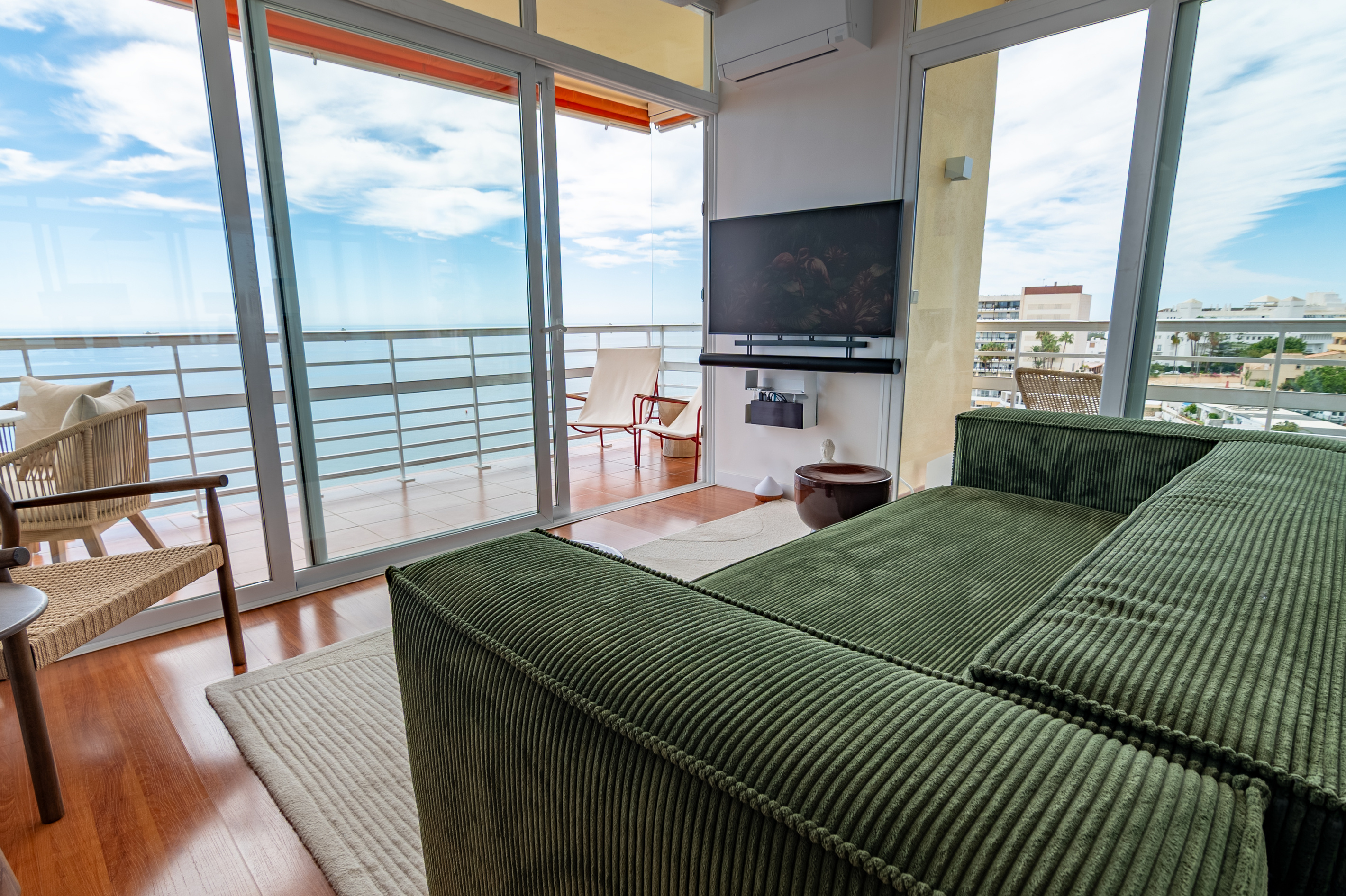 Bright living area with floor-to-ceiling windows and sea views