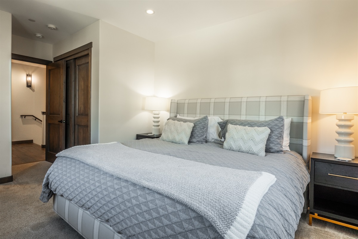 The second primary bedroom centers around a comfortable king bed layered in cozy linens—an inviting, restful space that makes it easy to settle in and sleep well.