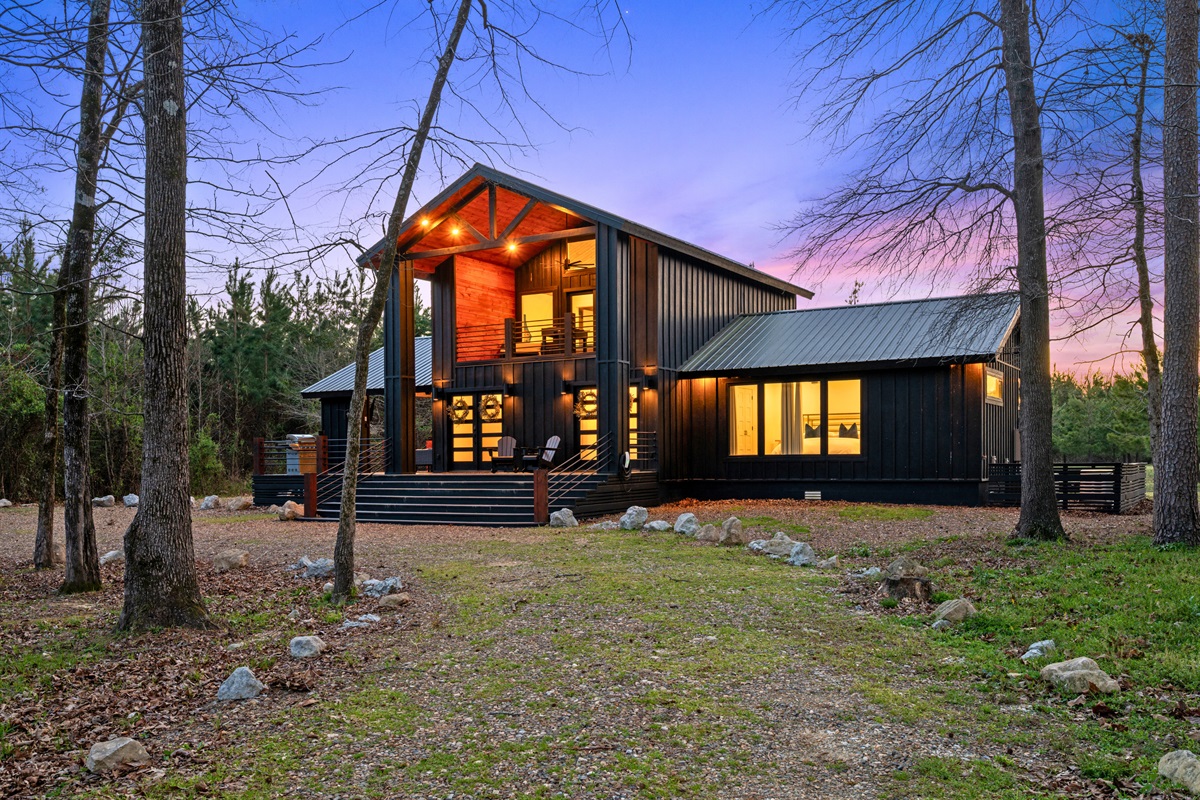 A side view of the cabin highlights its unique architecture and the way the outdoor spaces are thoughtfully integrated.