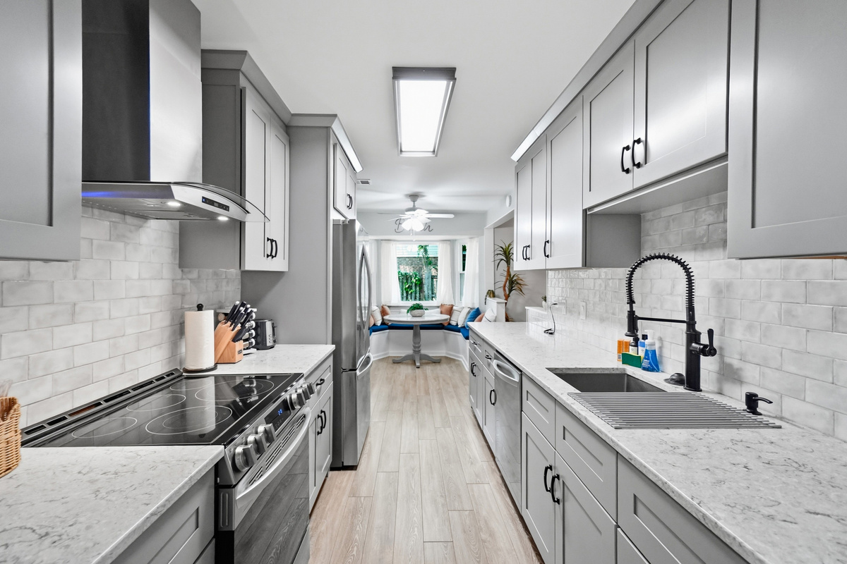 The renovated kitchen features stainless-steel appliances, generous counter space, and modern finishes.