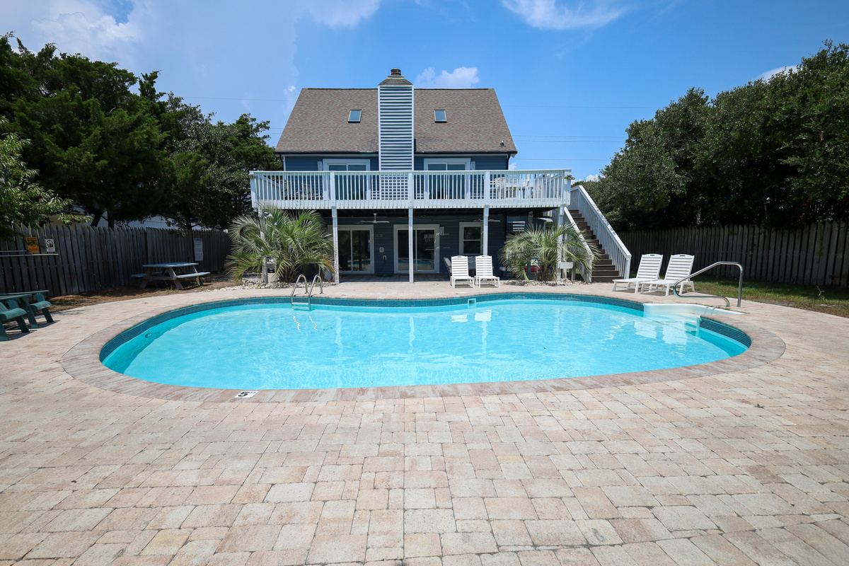 The backyard features a large private pool, covered patio, hot tub, and plenty of space for the whole group to enjoy