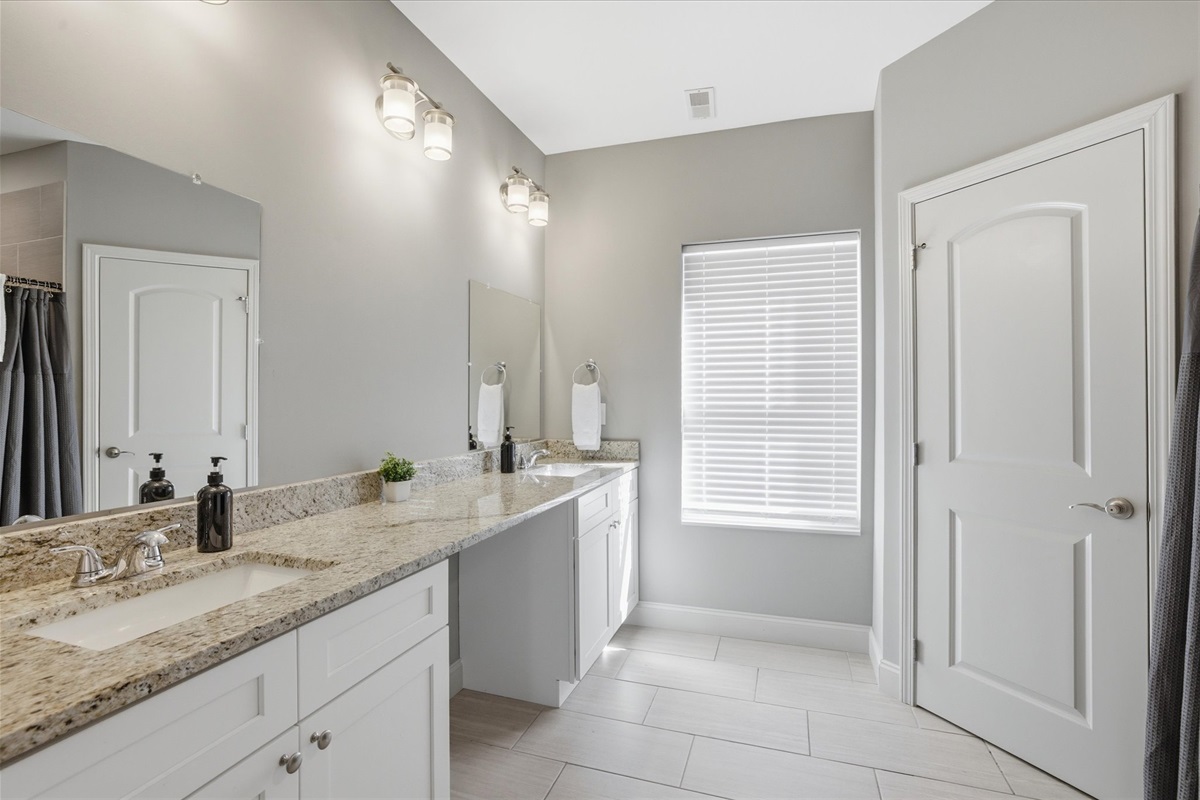 In Unit 1, this guest bathroom gives you room to actually get ready—double sinks, bright lighting, and enough space to spread out without bumping into each other. It keeps mornings smooth and evenings easy.