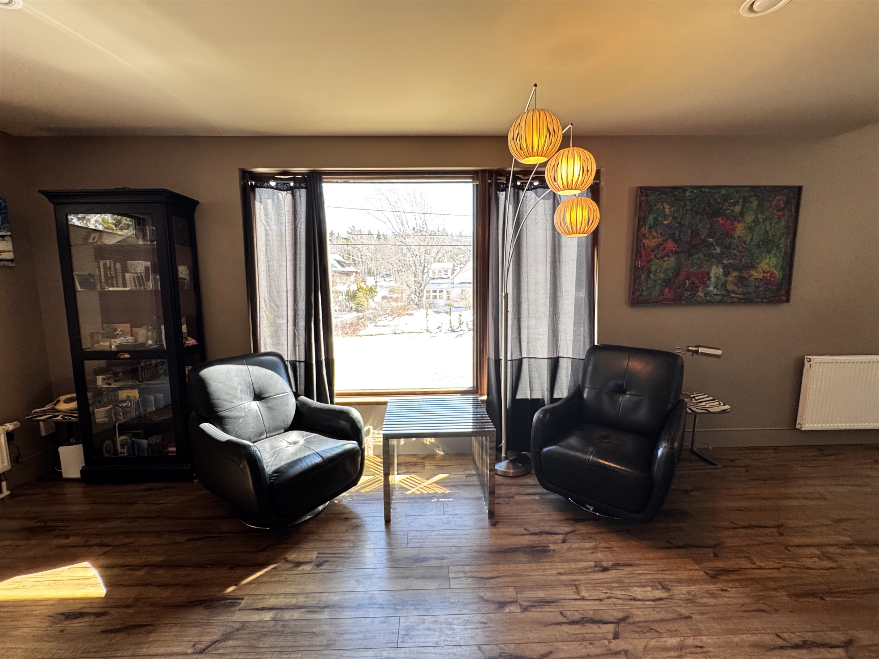 Bright, open landing at the base of the third-floor stairway. This versatile space connects the designer office and the main-level master suite, offering a quiet, sun-drenched area to decompress while overlooking the village of Otter Creek.